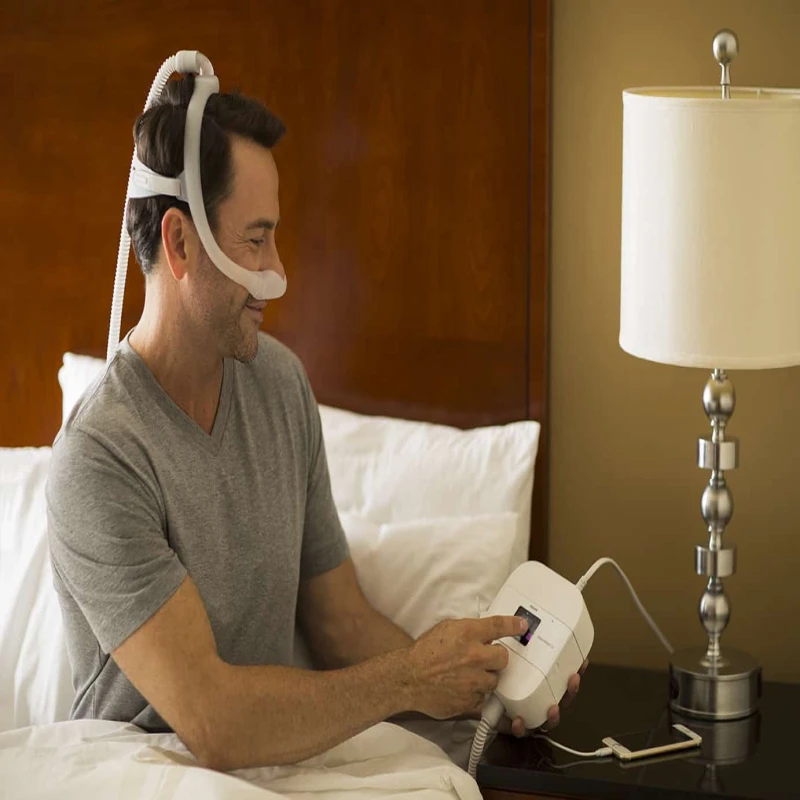 DreamStation Go portable CPAP machine in bedroom sleep therapy